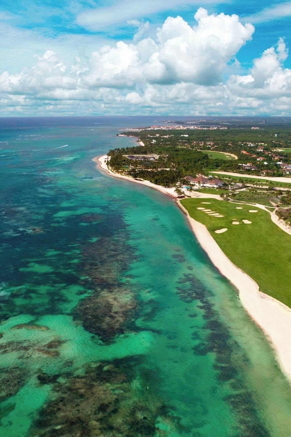 Aerial view of an oceanfront golf course beside the reef on the Punta Cana coast